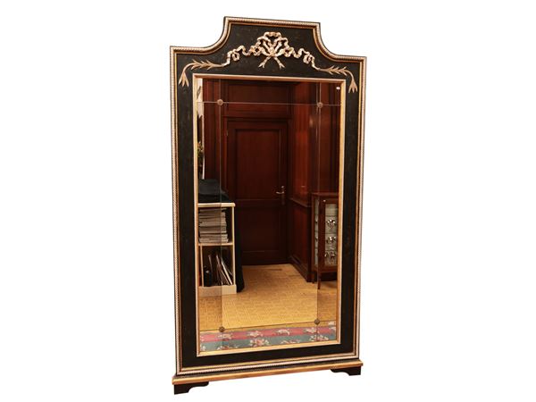 Large mirror in the back of the room in carved wood, ebonized and highlighted in gold