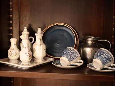 Assortimento di accessori per la casa: oliera in ceramica, tazze e tazzine, accessori in peltro