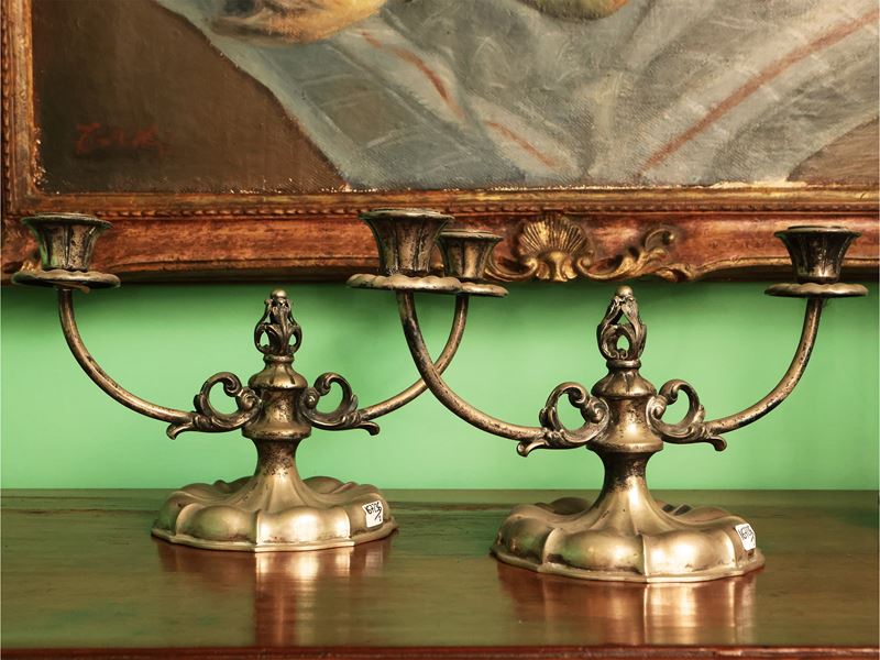 Coppia di candelieri in argento, con stemmi a voluta e decorazioni in foglia d'acanto