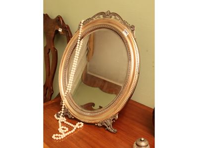 Specchio da toilette ovale con cornice in argento sbalzata