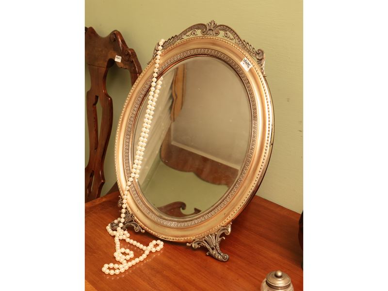 Specchio da toilette ovale con cornice in argento sbalzata