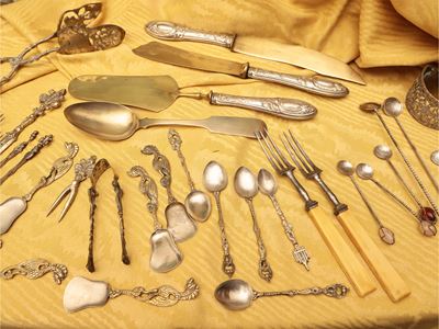 Grande assortimento di posate in metallo argentato e dorato con accessori da tavola