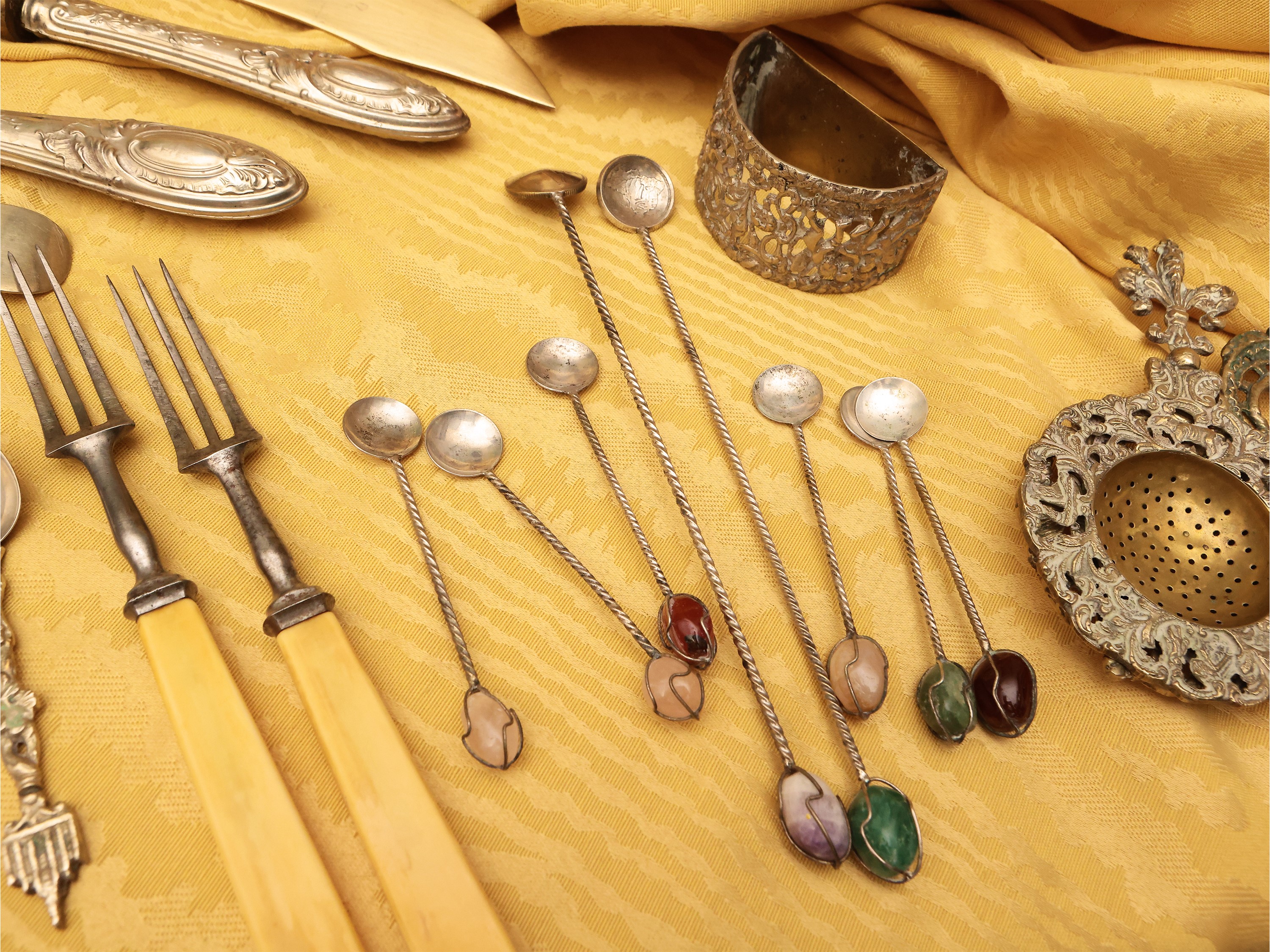 Grande assortimento di posate in metallo argentato e dorato con accessori da tavola