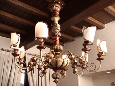 Lampadario in legno intagliato, laccato e dorato, con otto bracci portacandele