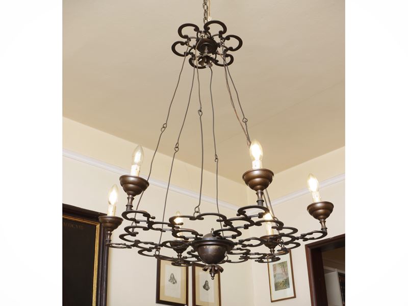 Lampadario in metallo brunito con quattro bracci portacandele e luce centrale