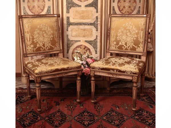 Coppia di sedie in legno laccato bianco e lumeggiato in oro