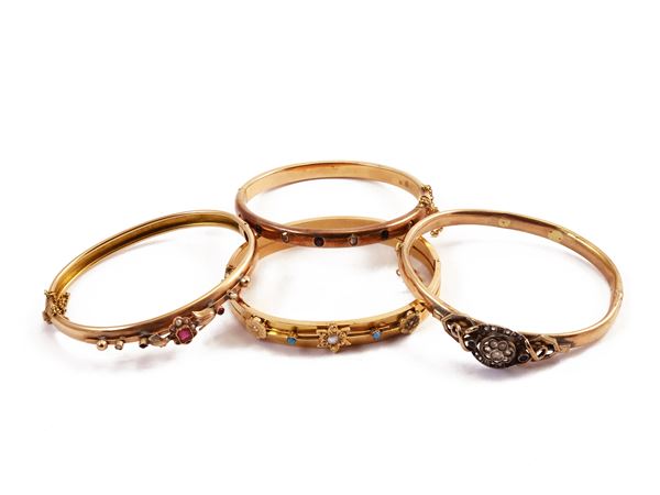 Four low title red and yellow gold bracelets with various gems