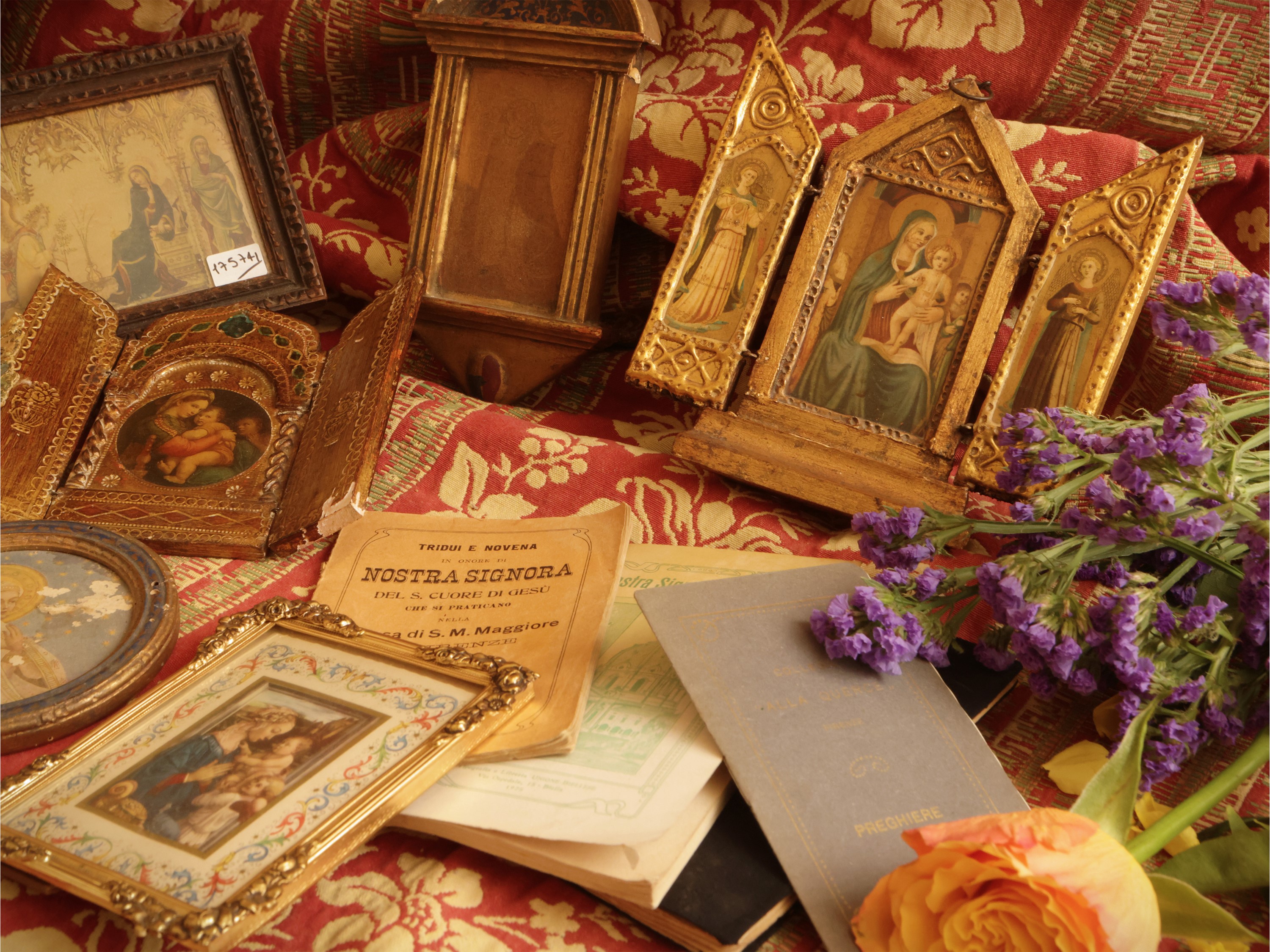 Miscellanea di curiosità devozionali: assemblaggio di spille, monete, pendenti, icone e dipinti