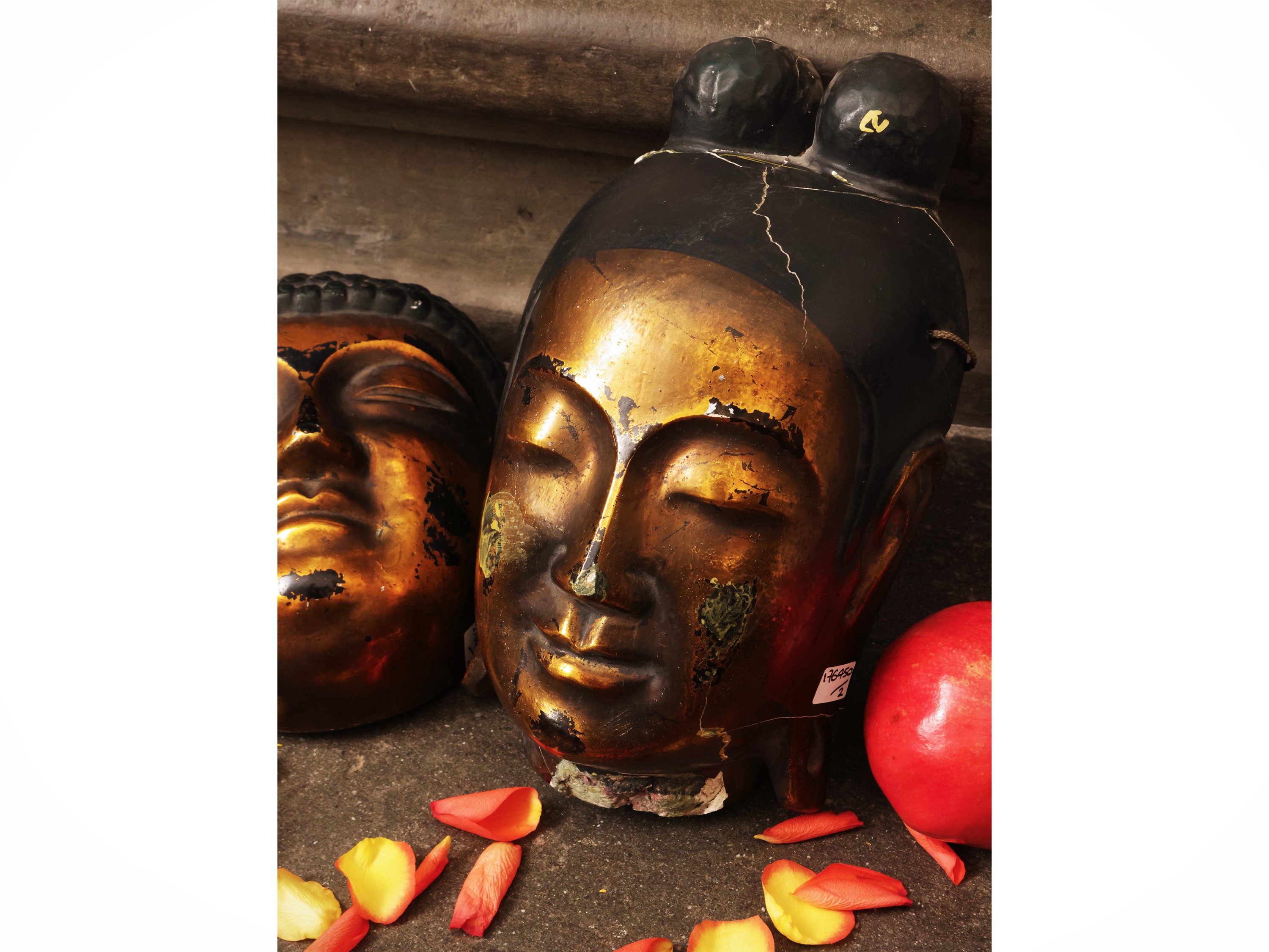Due maschere orientali, raffiguranti teste di Buddha