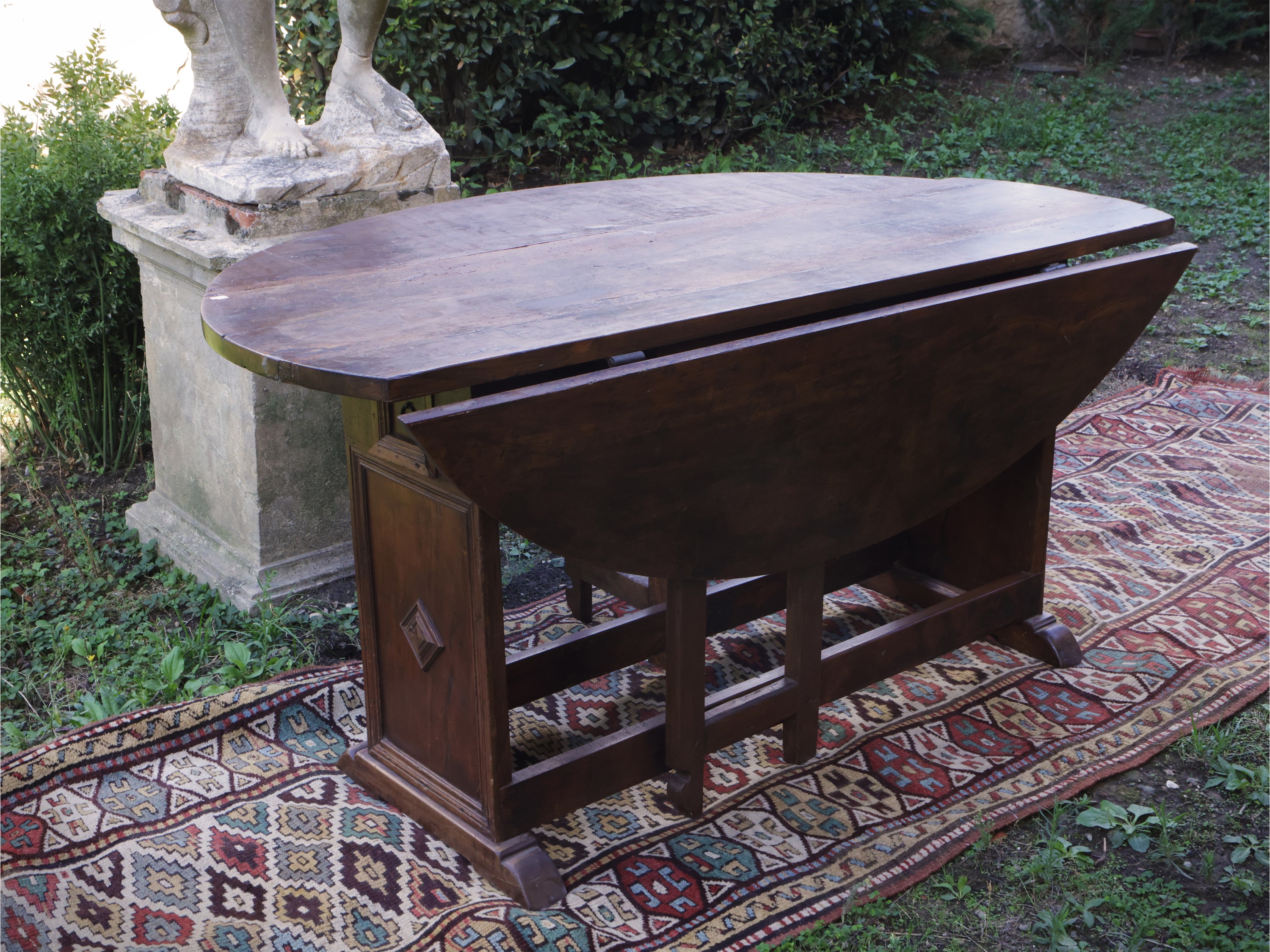 Tavolo console a bandelle in noce, intarsiato con sostegni laterali e cassettino