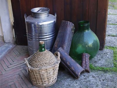 Accessori rustici, fusto da olio in acciaio e damigiane da vino in vetro verde