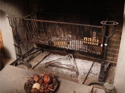 Complementi da camino d'epoca, includente rastrelliera portalegna e coppia di alari con finali