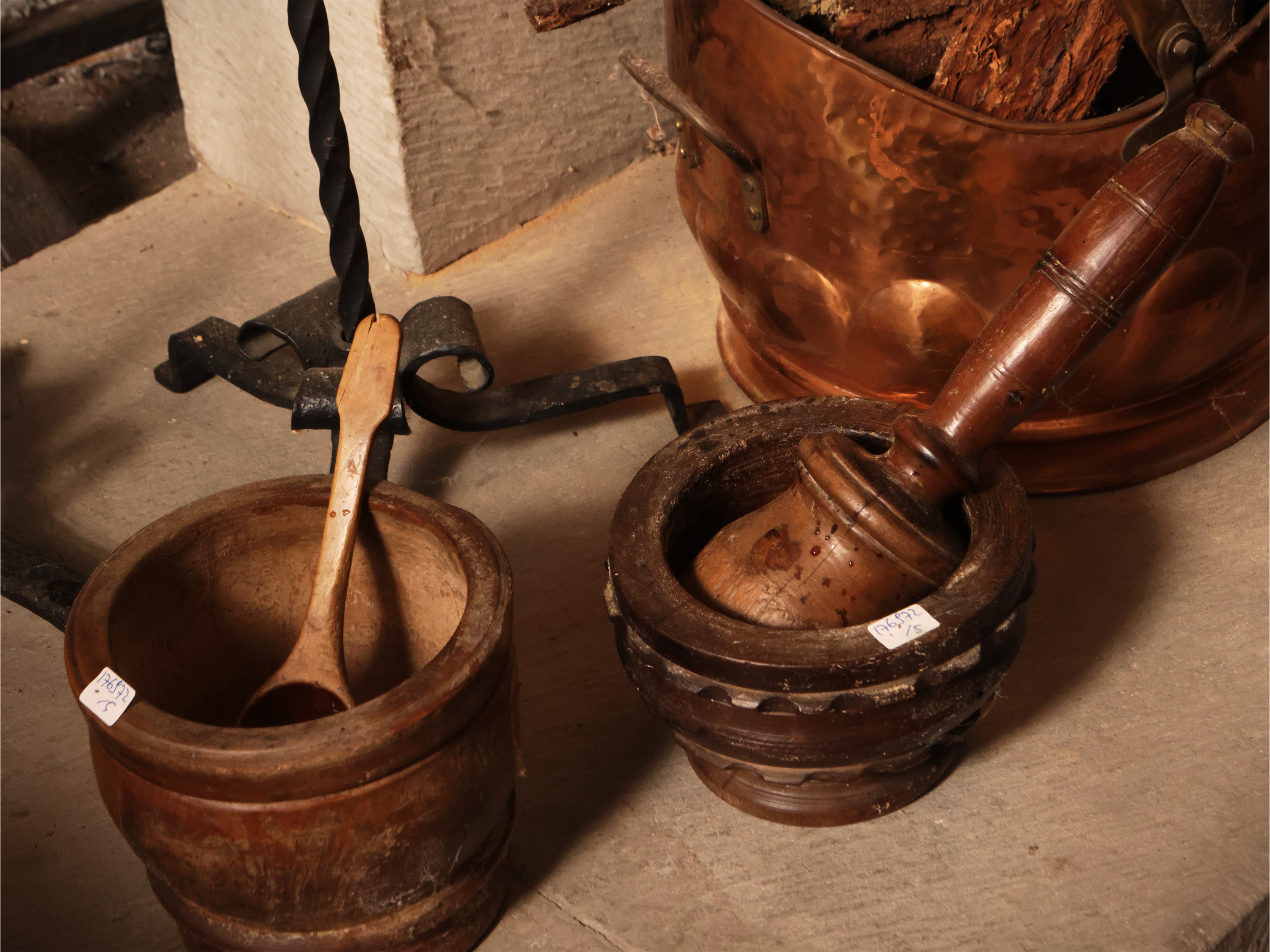 Assortimento di accessori rustici: due torciere in ferro battuto su tripode, due mortai in legno ...