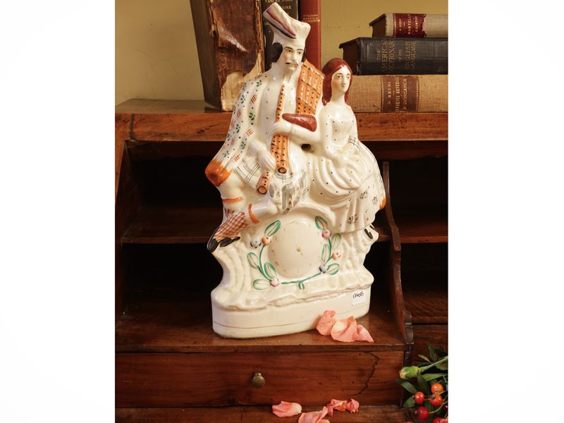 Gruppo in terraglia Staffordshire, XIX secolo, imitazione di orologio con figura scottese