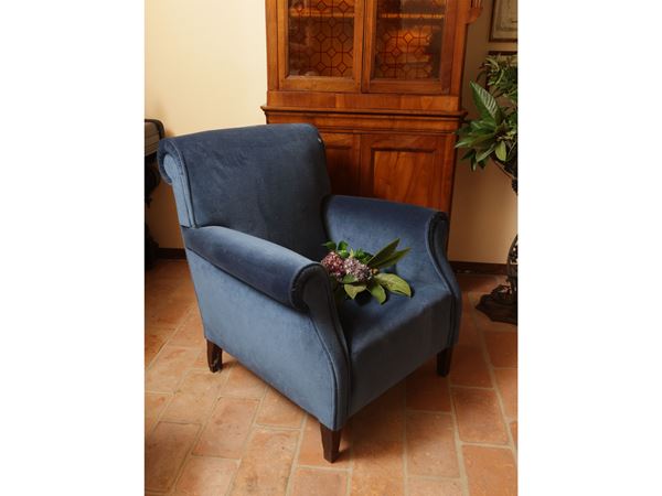 Padded armchair and covered in blue velvet