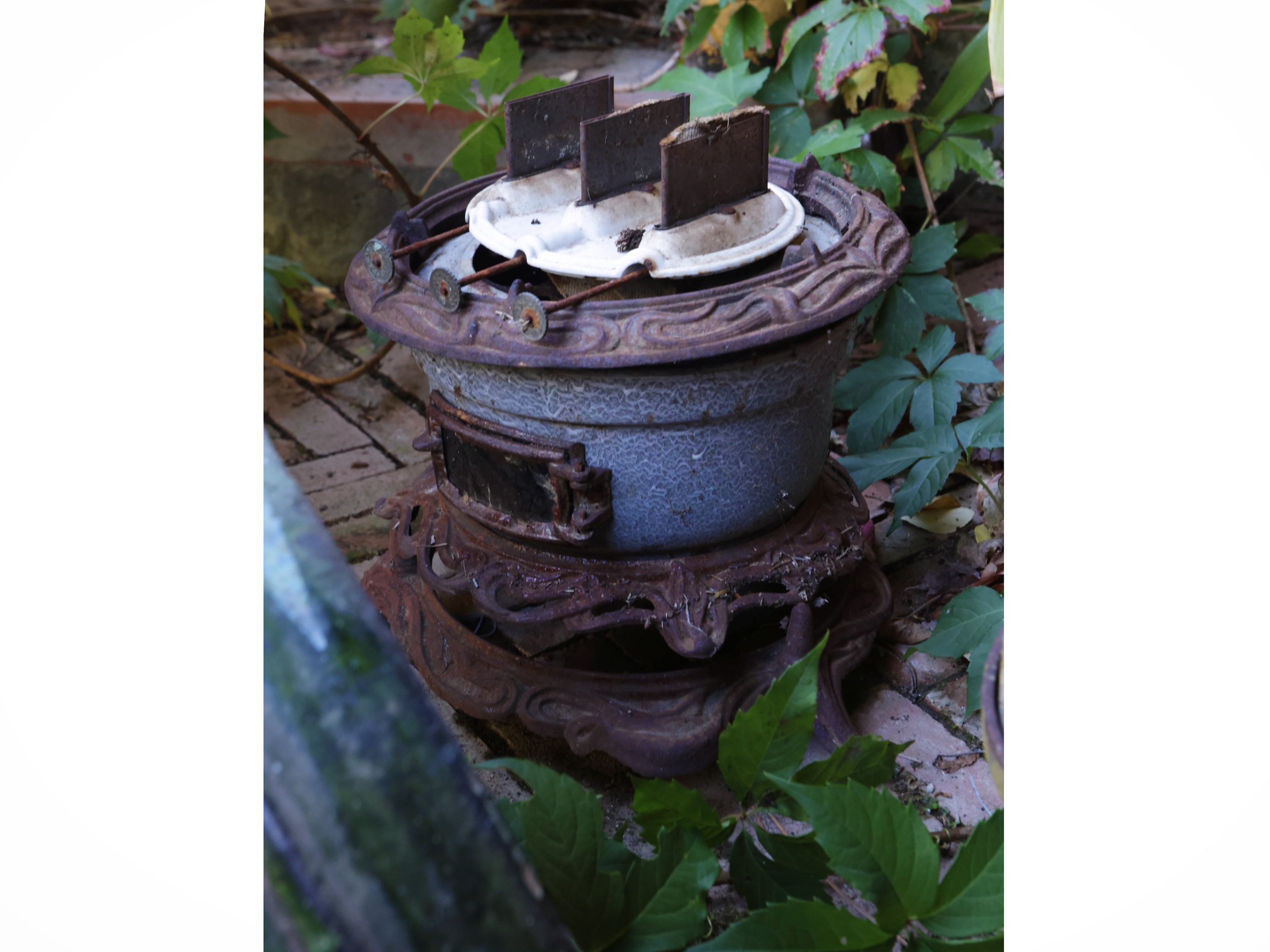 Arredi da giardino, stufa in ghisa, cachepot e due vasi in terracotta smaltata, XIX/XX secolo
