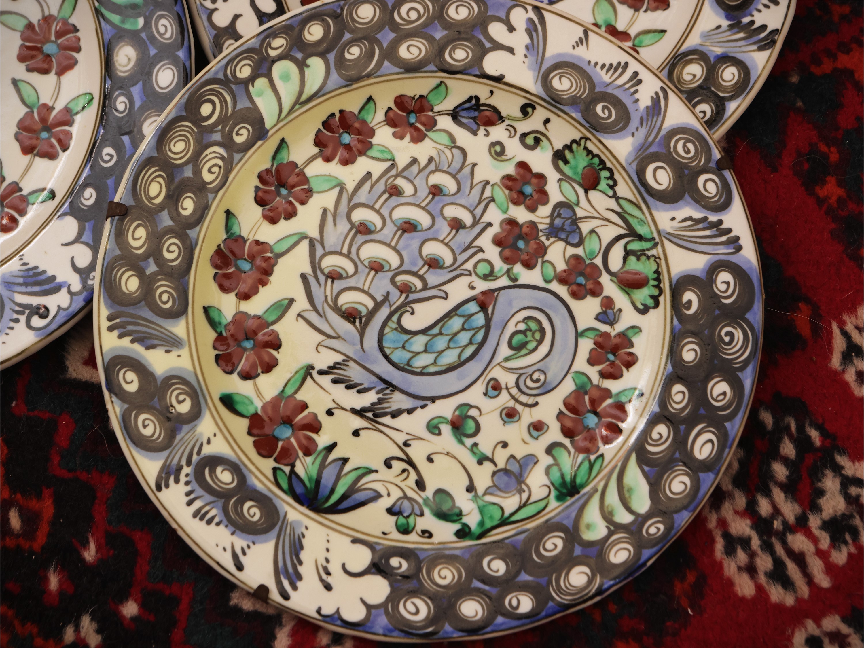 Serie di sei piatti in ceramica, decorazione animalier e tralci floreali