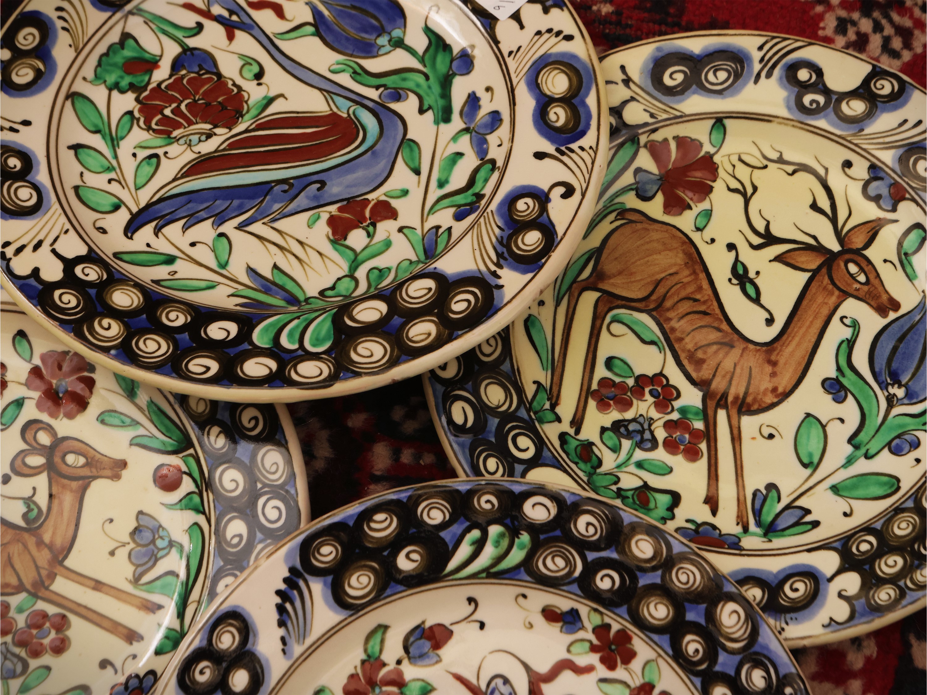 Serie di sei piatti in ceramica, decorazione animalier e tralci floreali