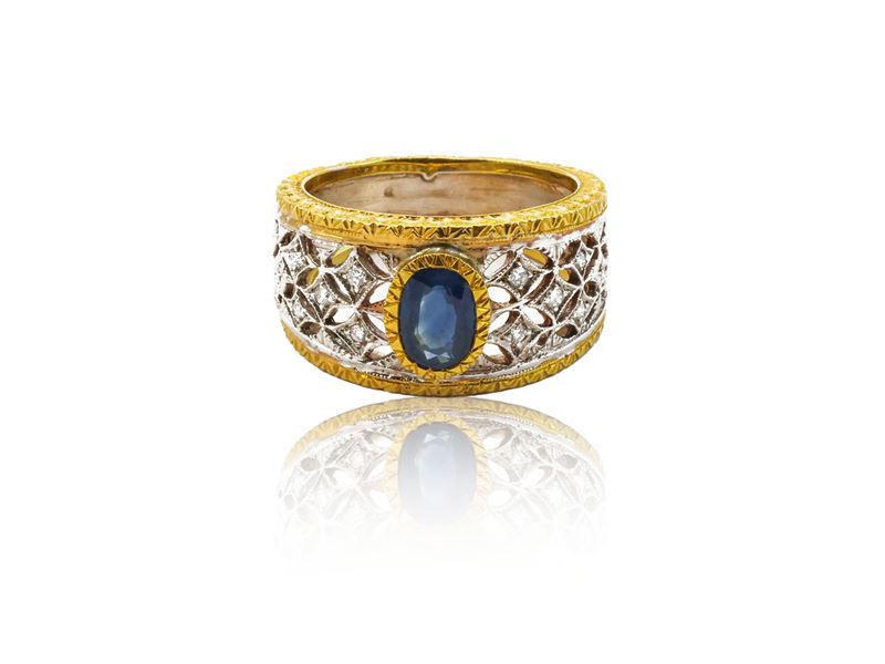 Anello a fascia in oro giallo e bianco con diamanti e zaffiro