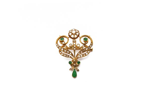 A liberty style brooch in 18K yellow gold, diamonds and emeralds