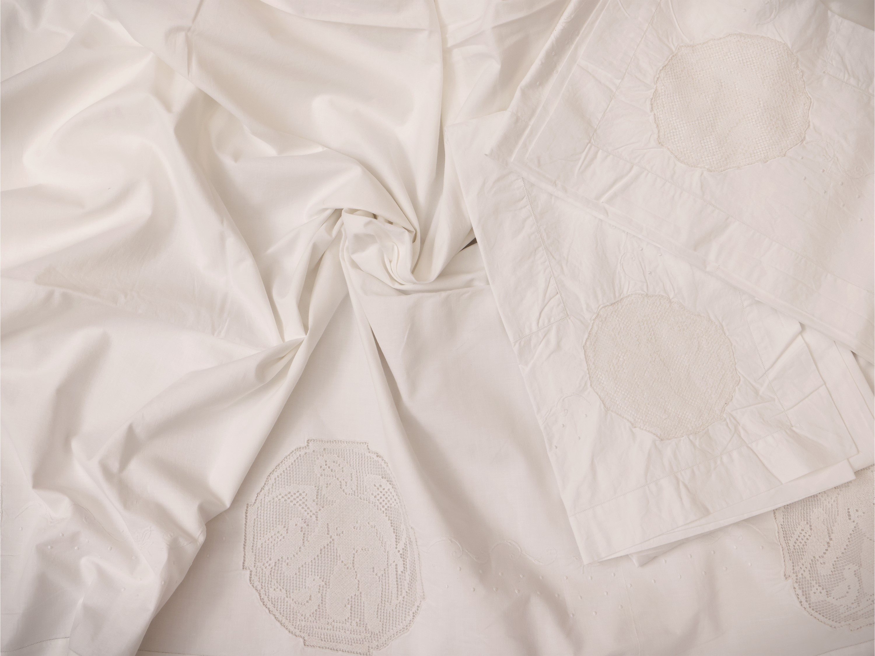 Due lenzuola matrimoniali in lino bianco con ricami floreali e inserti in filet