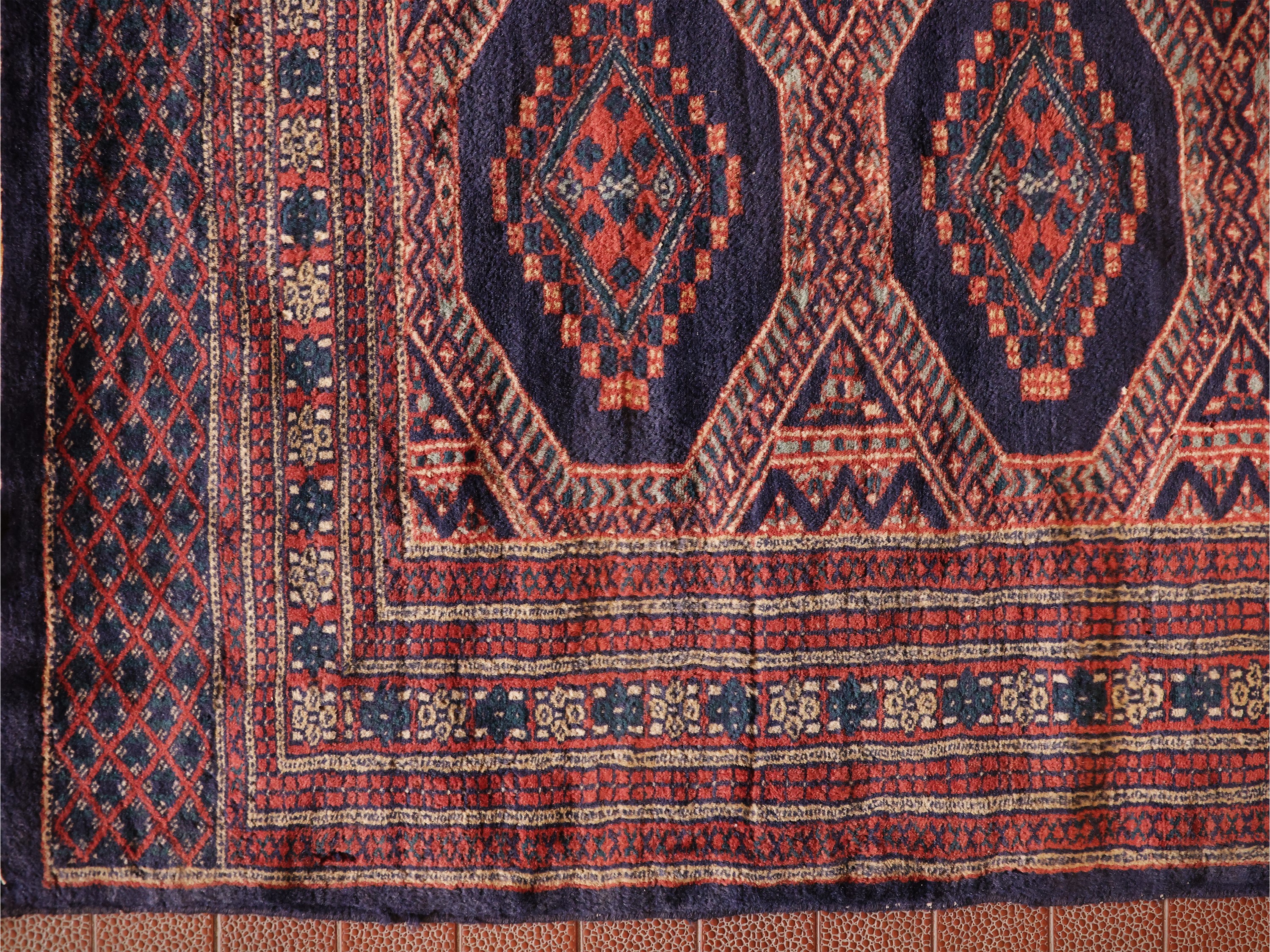 Tappeto Bukara, campo con medaglioni geometrici in toni rosso, blu e arancio
