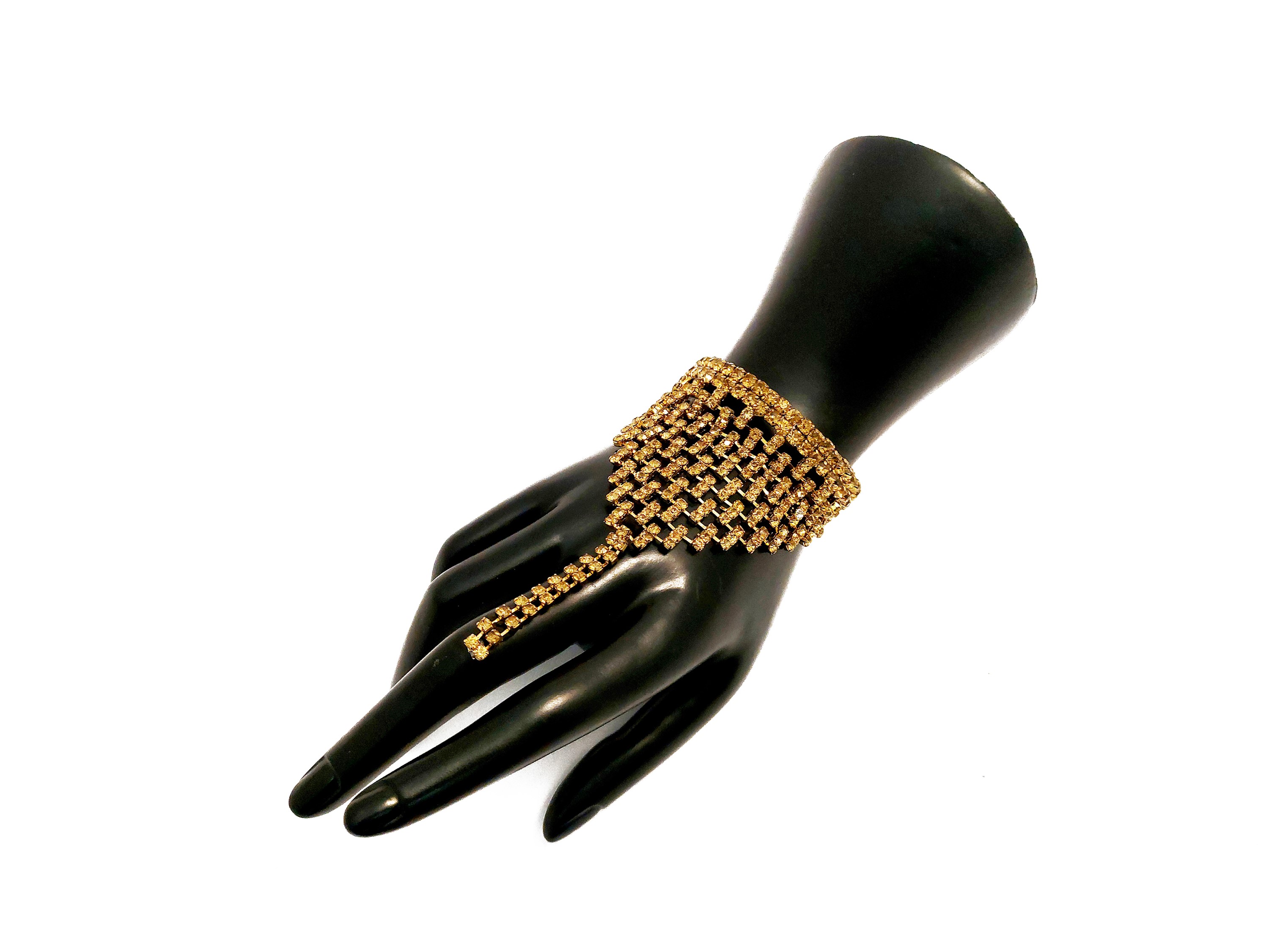 Bracciale semirigido in metallo dorato con strass color topazio