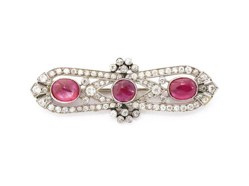 Spilla in oro bianco, piccoli diamanti e rubini cabochon