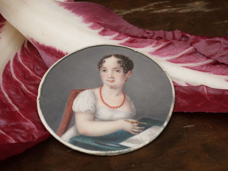 Ritratto di fanciulla intenta alla scrittura con gioielli in corallo