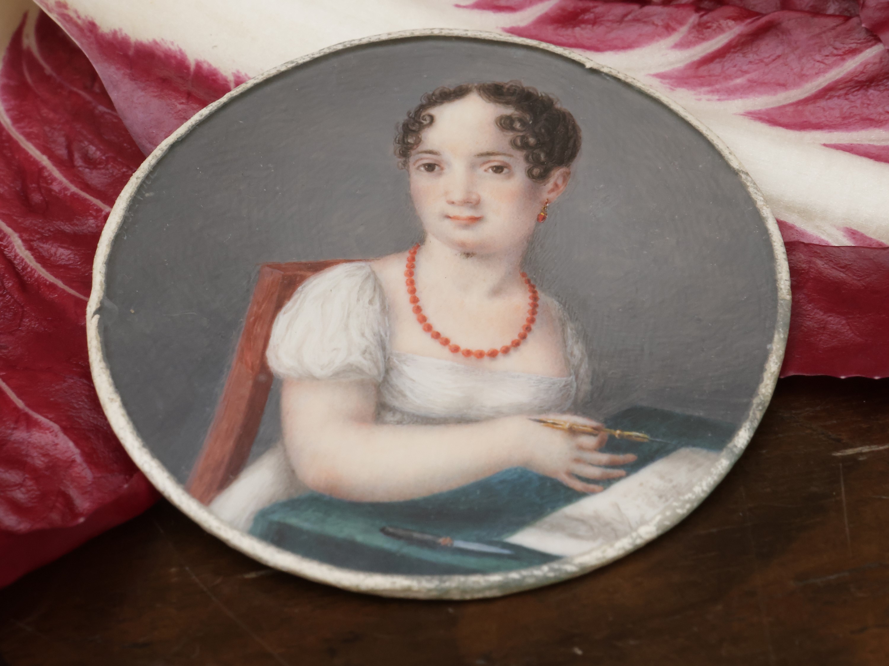 Ritratto di fanciulla intenta alla scrittura con gioielli in corallo