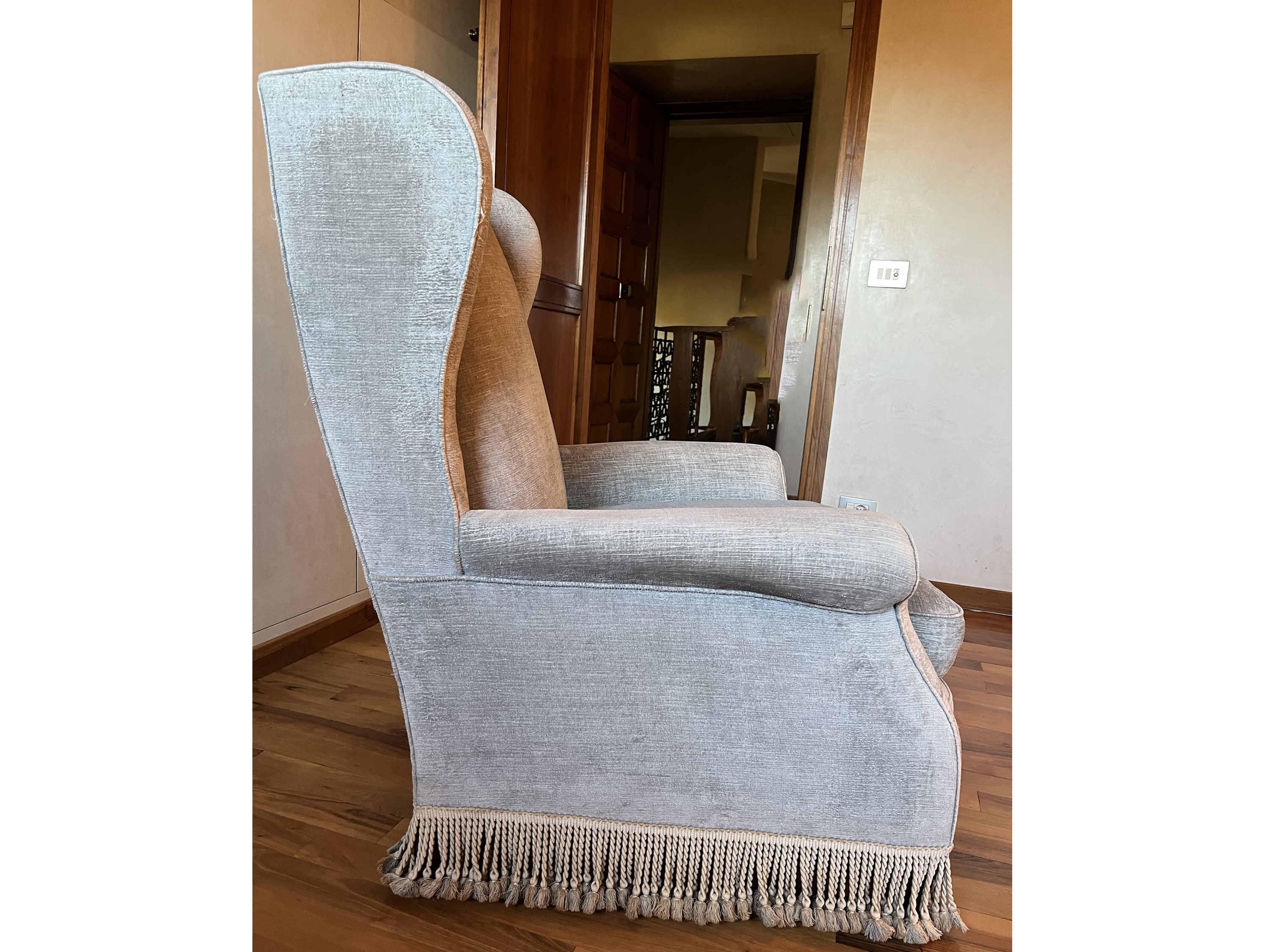 Poltrona bergère imbottita, velluto celeste polvere con bordura frangiata