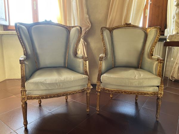 Pair of carved and gilded wooden armchairs