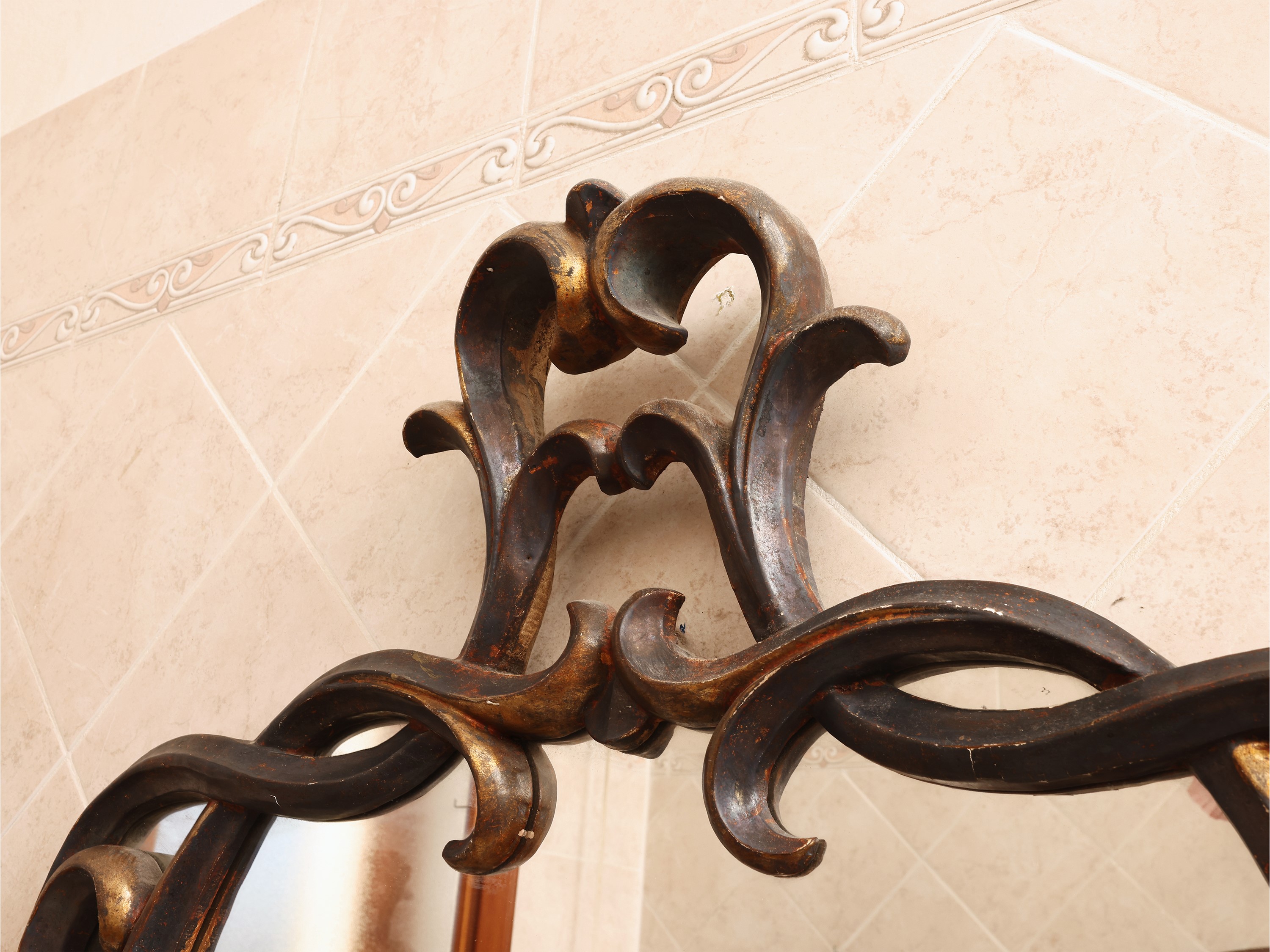 Specchiera sagomata, cornice in legno dorato con cimasa a volute