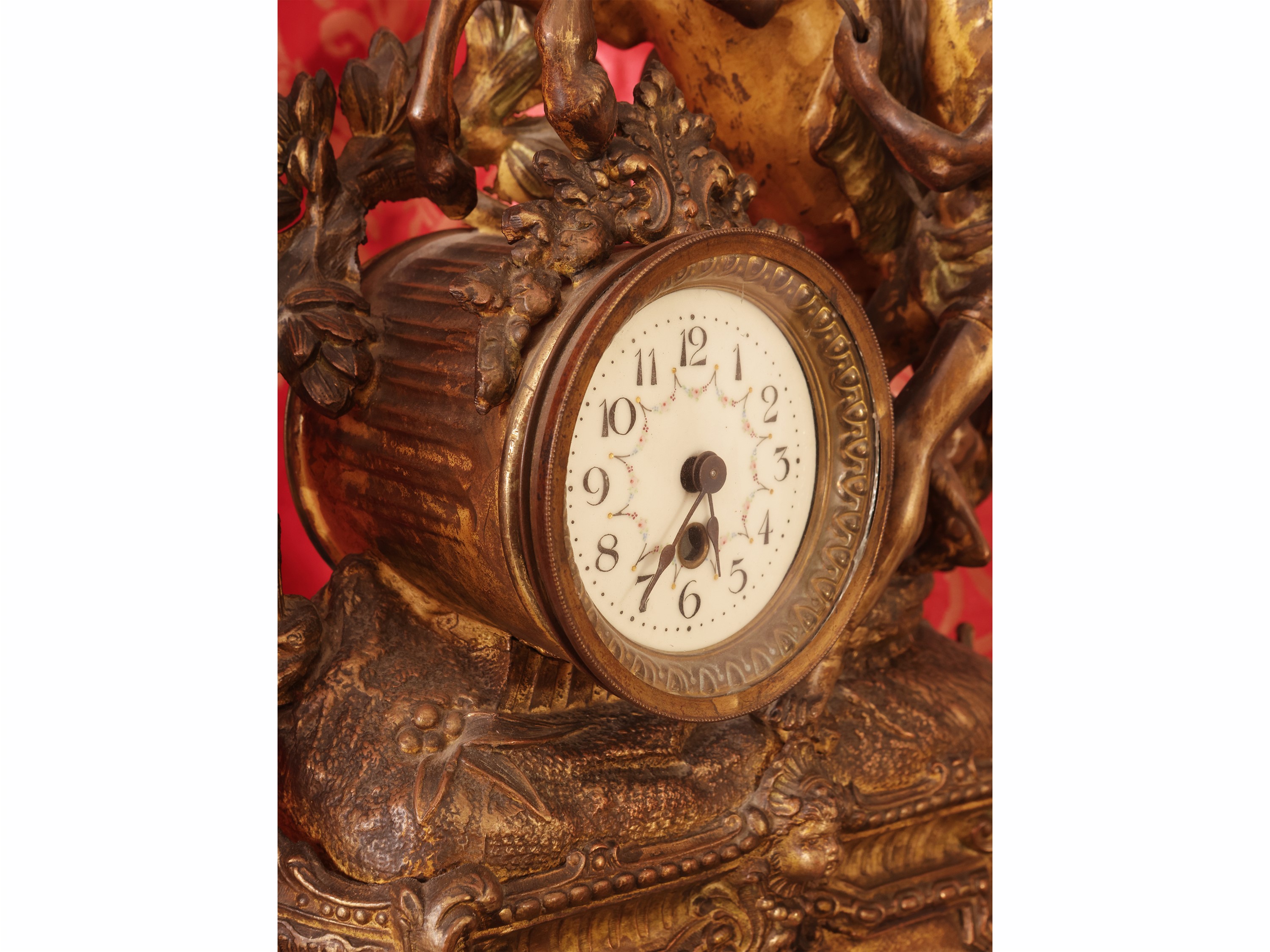 Trittico in antimonio dorato, orologio da tavolo sormontato da scena equestre con coppia di cande...