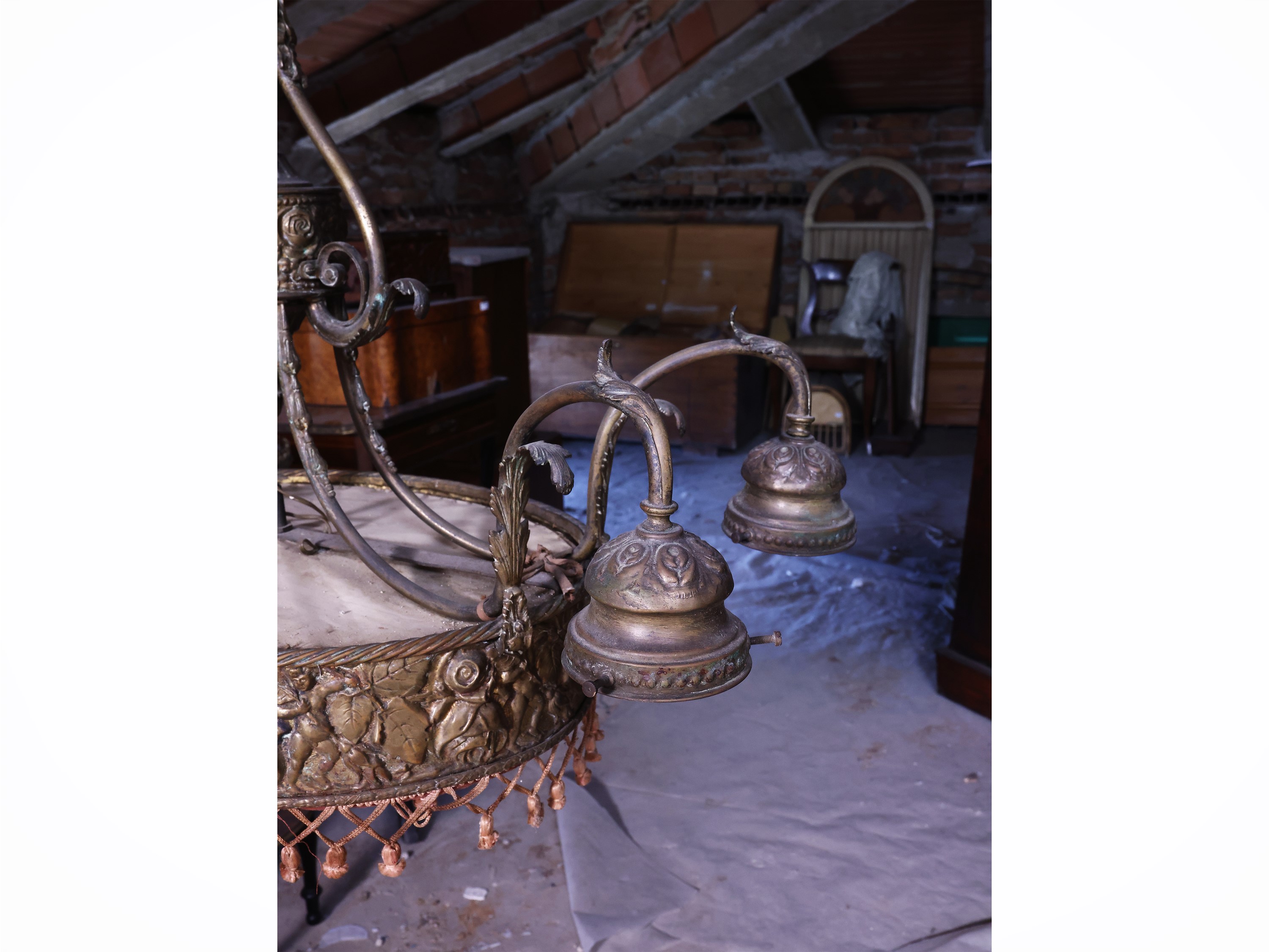 Lampadario in lamiera dorata, ovale, sbalzato con motivi floreali e putti