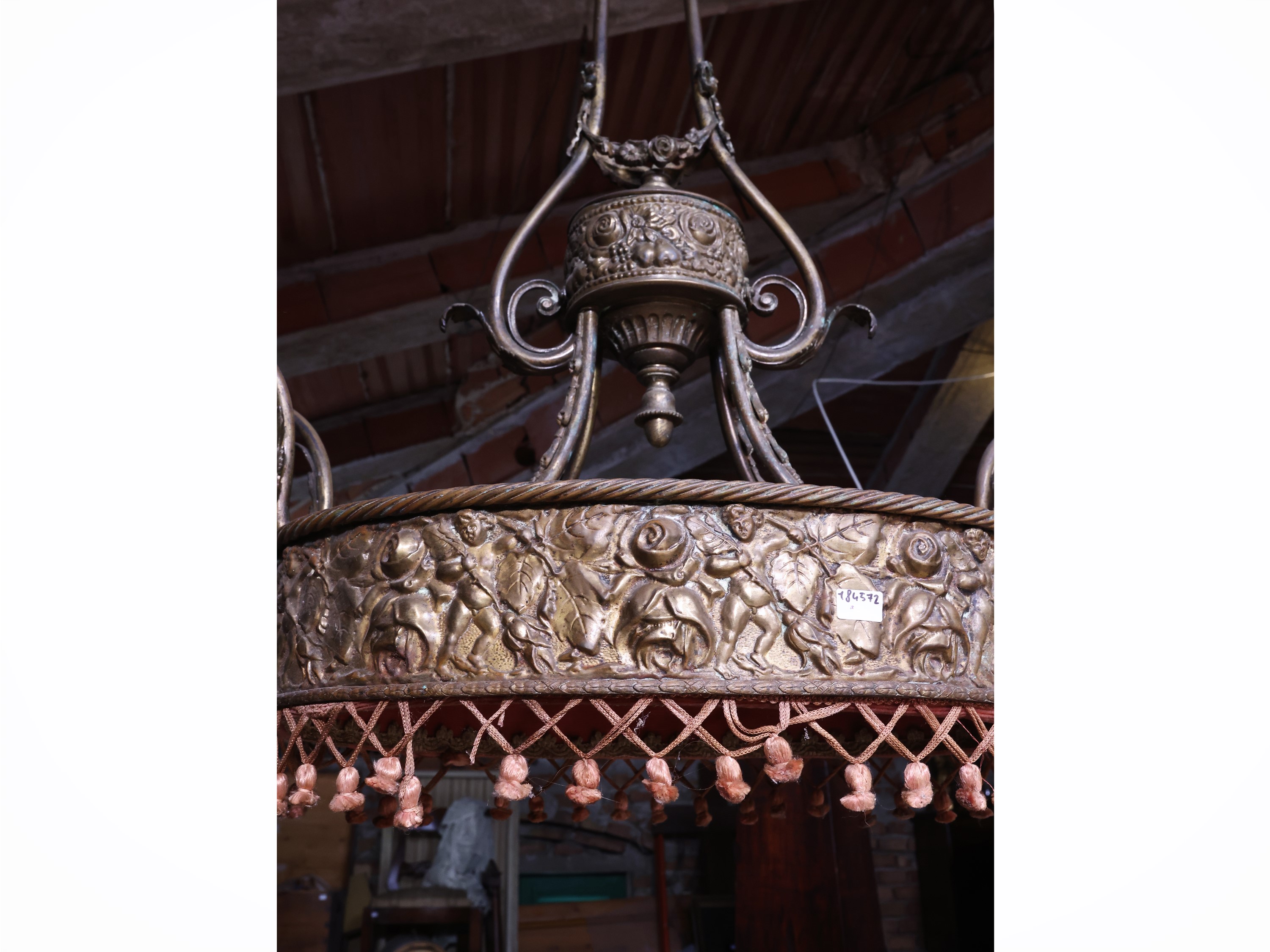 Lampadario in lamiera dorata, ovale, sbalzato con motivi floreali e putti