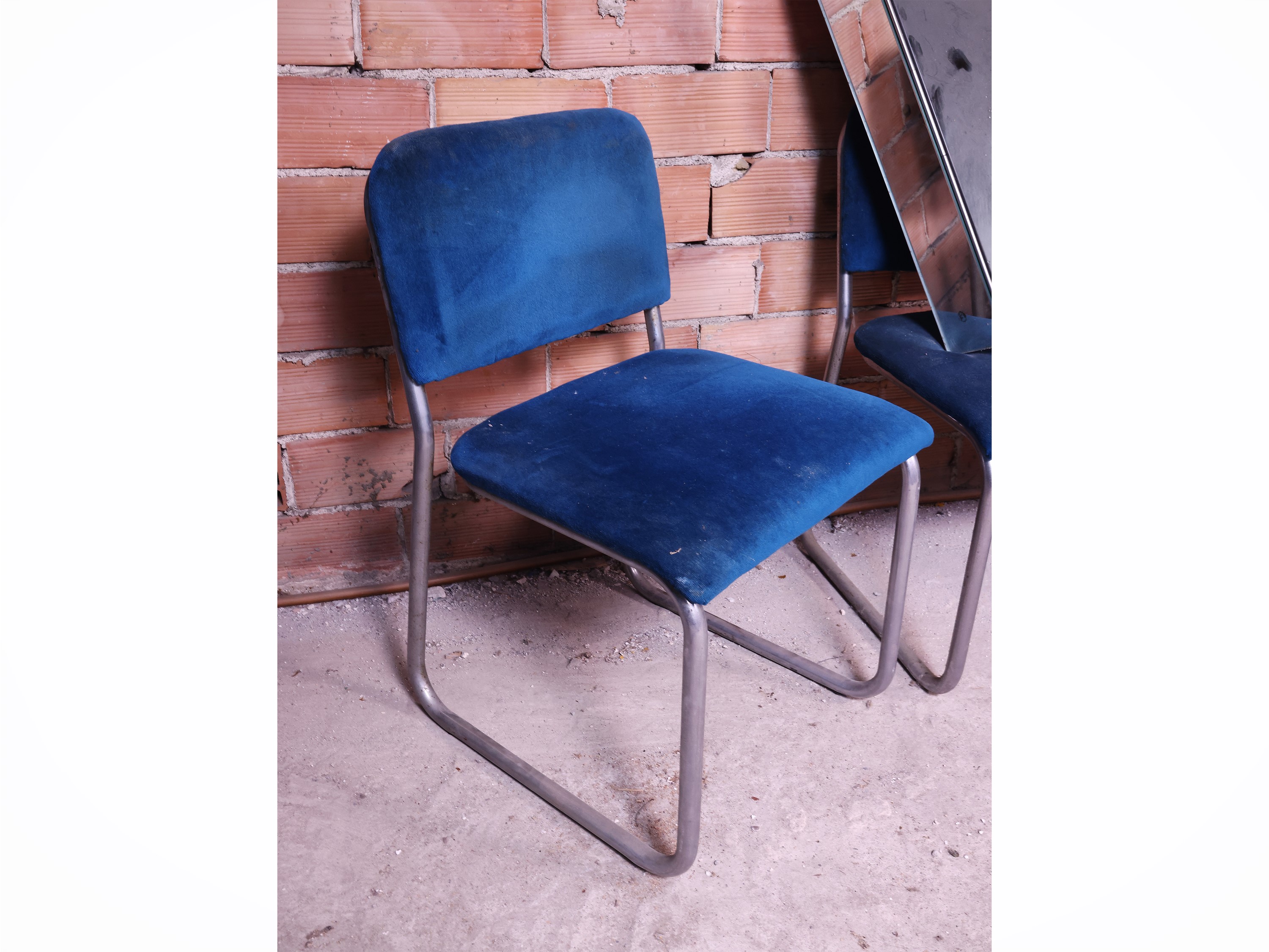Complementi di arredo di modernariato: tre sedie in acciaio rivestite in velluto bluette