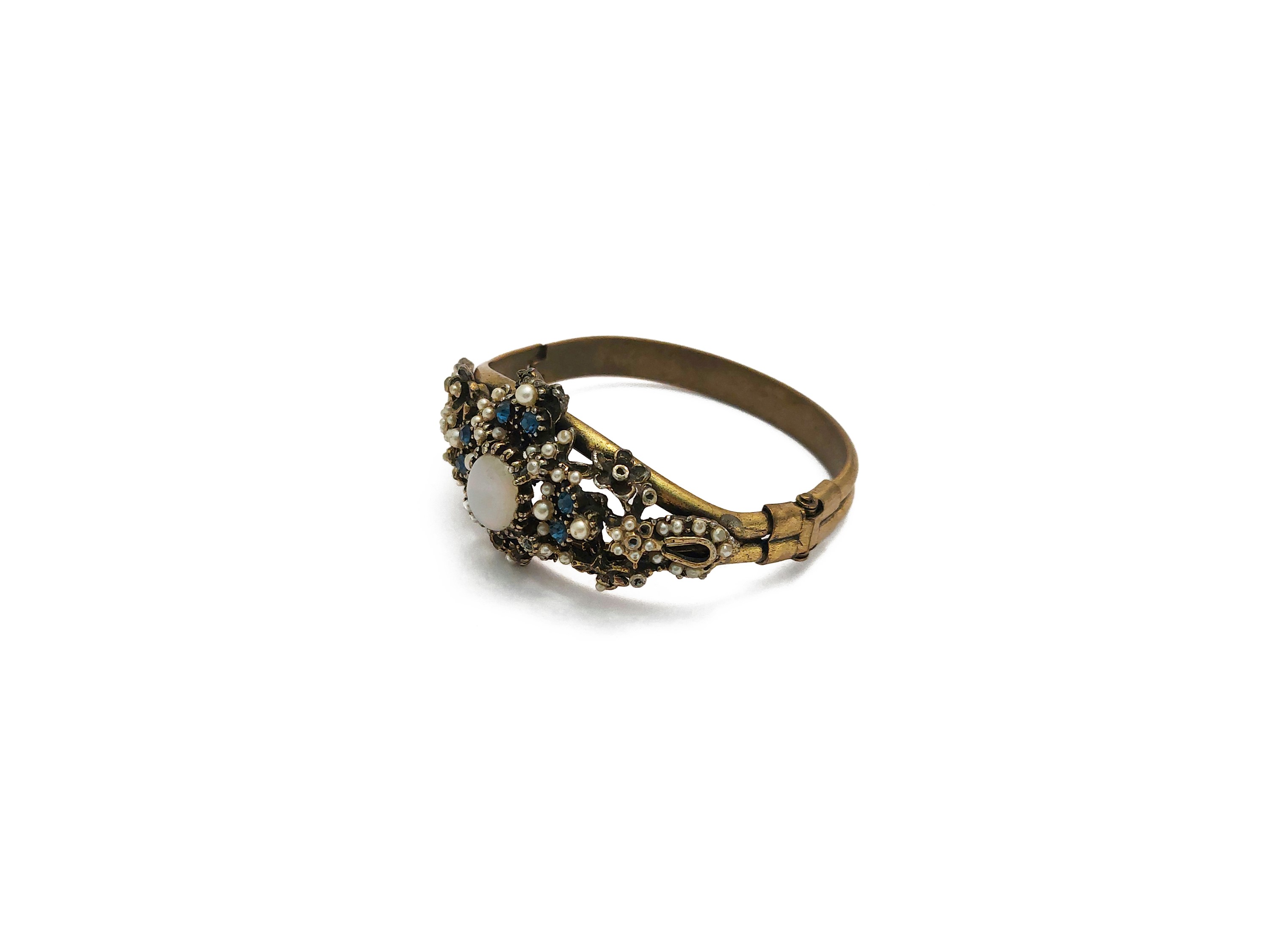 Bracciale rigido in metallo dorato con motivo floreale e opale cabochon centrale