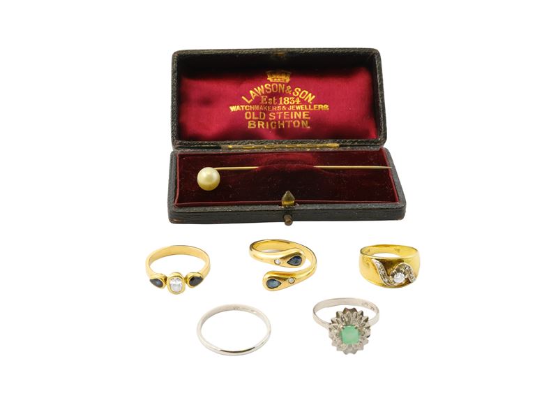 Cinque anelli in oro bianco, oro giallo, diamanti, zaffiri, smeraldo e uno spillone da cravatta