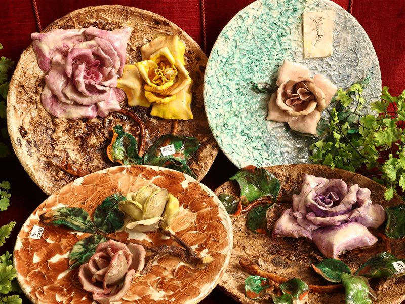 Quattro piatti in cartapesta con decorazione floreale in rilievo