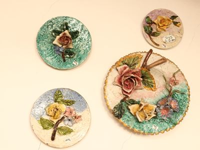 Tre piatti in terraglia decorati con fiori in rilievo, Italia meridionale, XIX/XX secolo