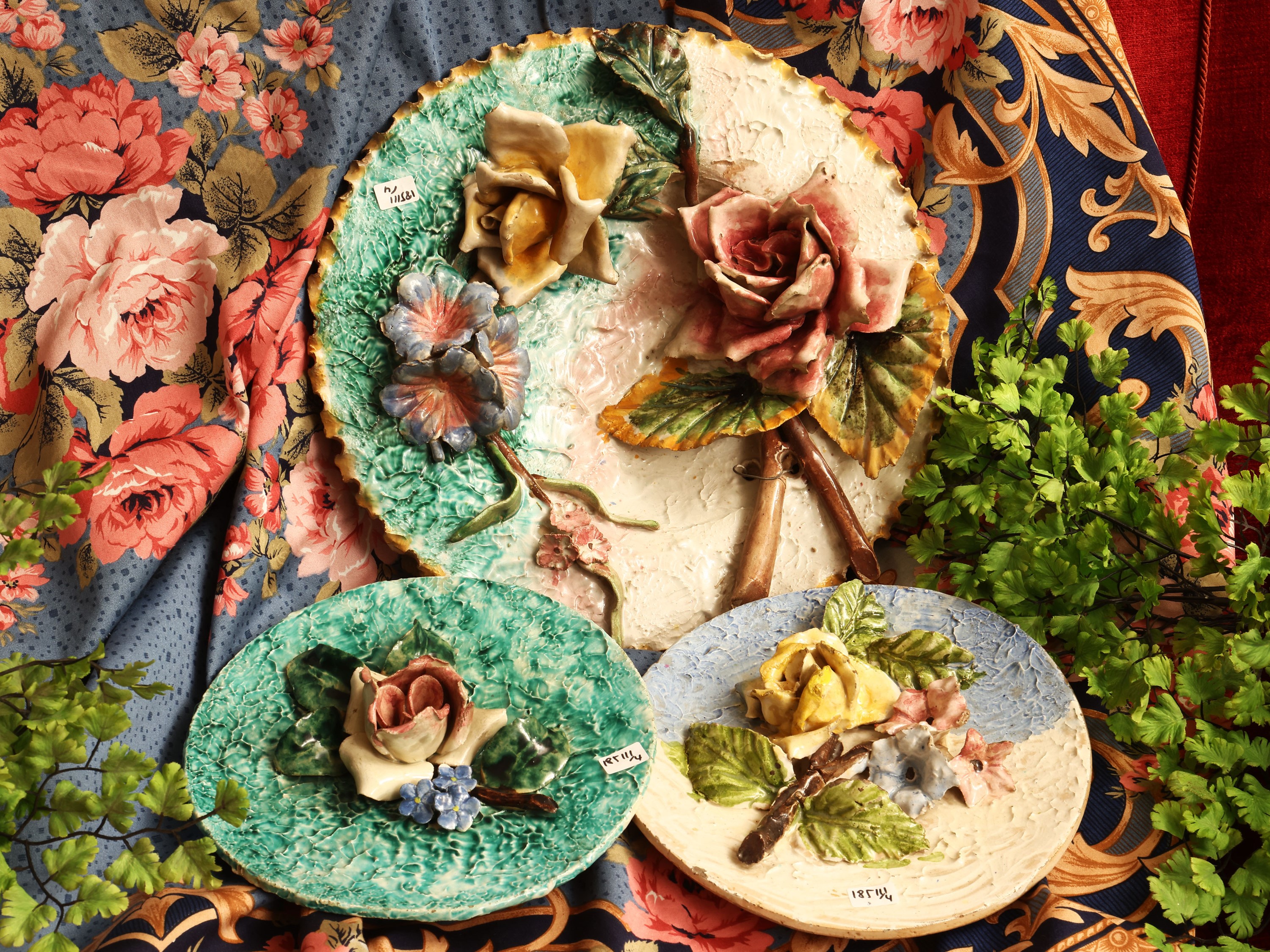 Tre piatti in terraglia decorati con fiori in rilievo, Italia meridionale, XIX/XX secolo