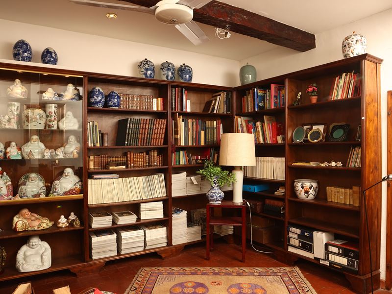Libreria angolare in noce con illuminazione interna e sportelli scorrevoli