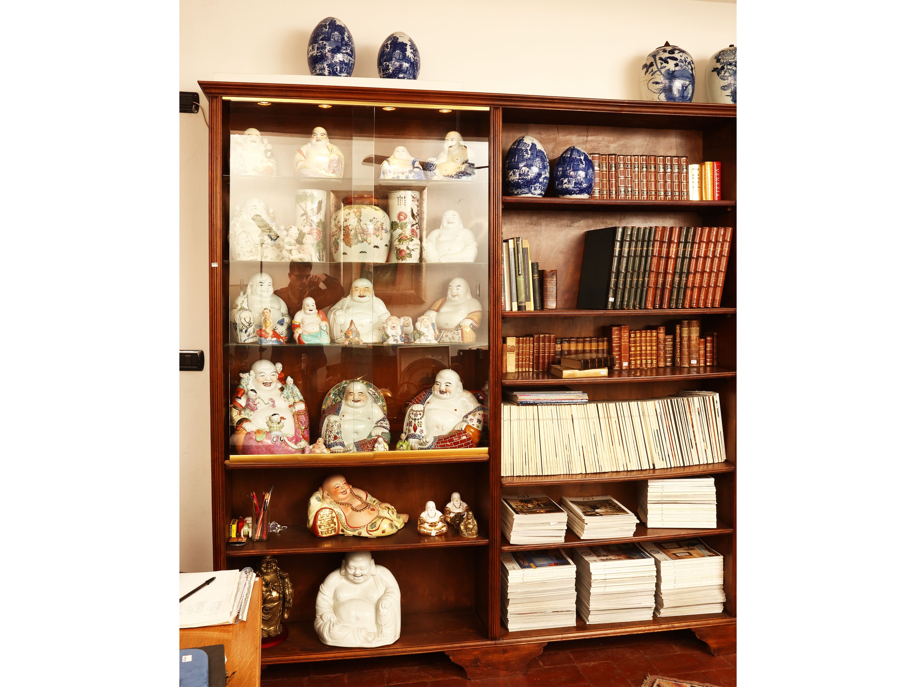 Libreria angolare in noce con illuminazione interna e sportelli scorrevoli