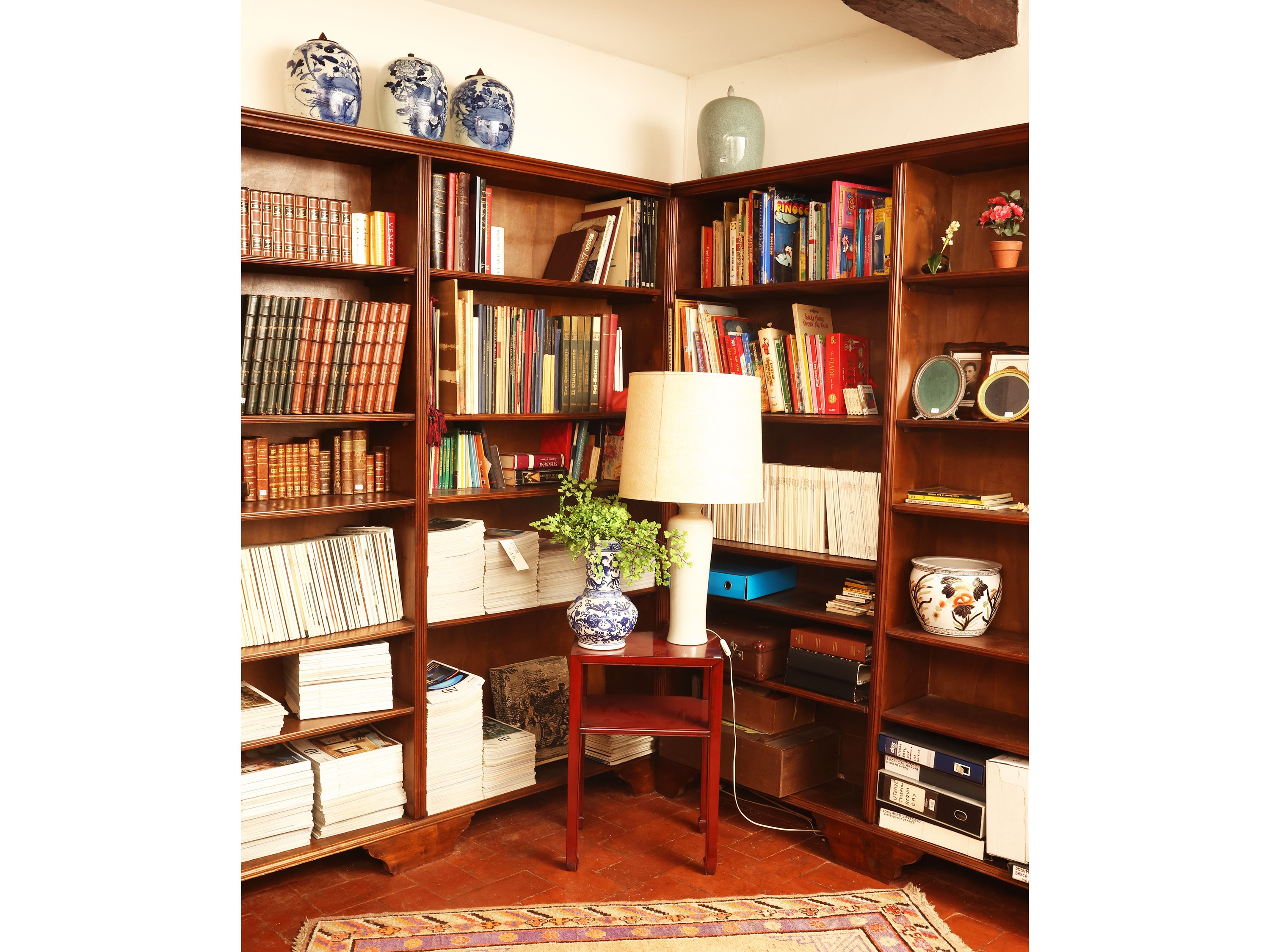 Libreria angolare in noce con illuminazione interna e sportelli scorrevoli