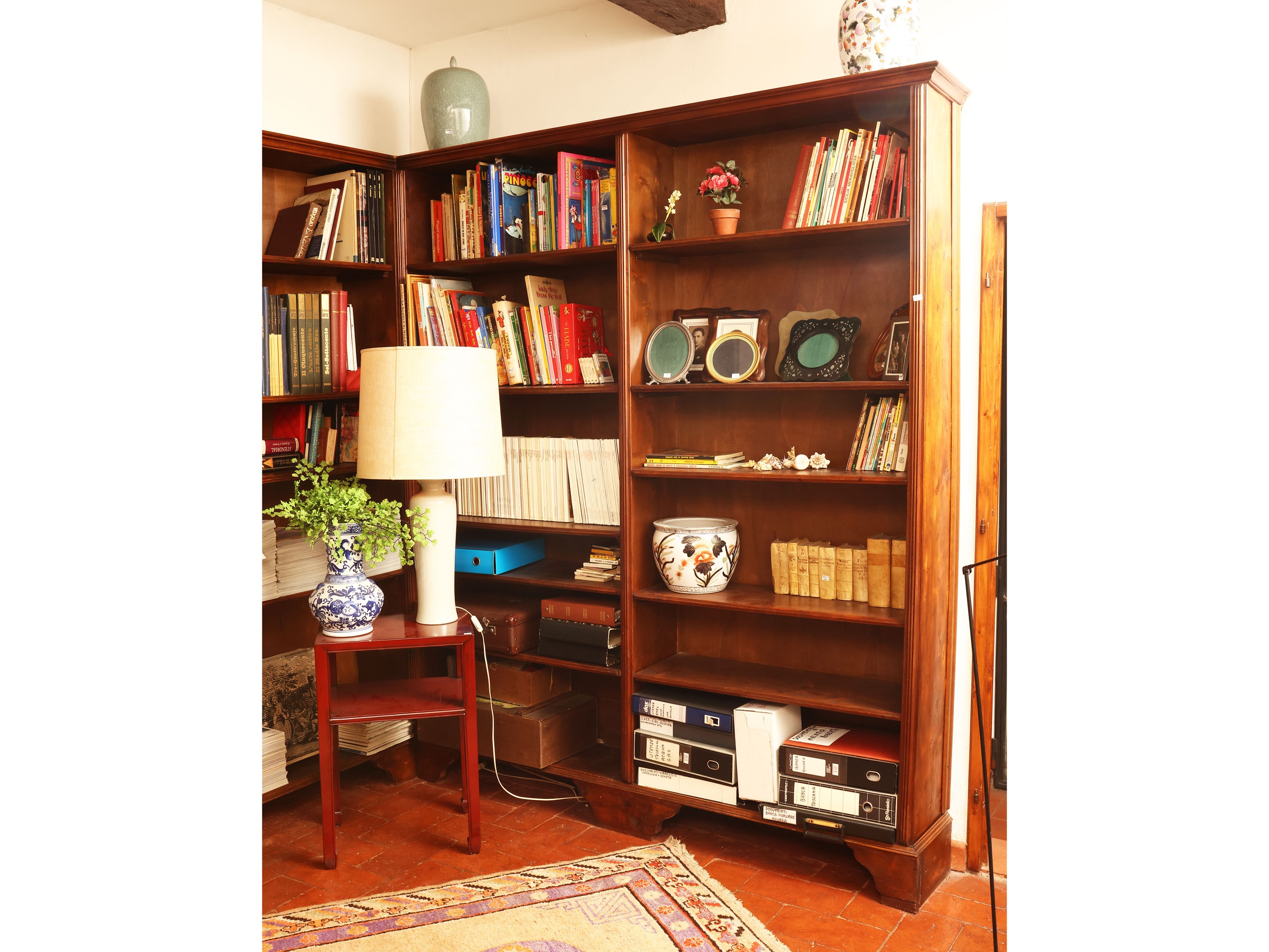 Libreria angolare in noce con illuminazione interna e sportelli scorrevoli
