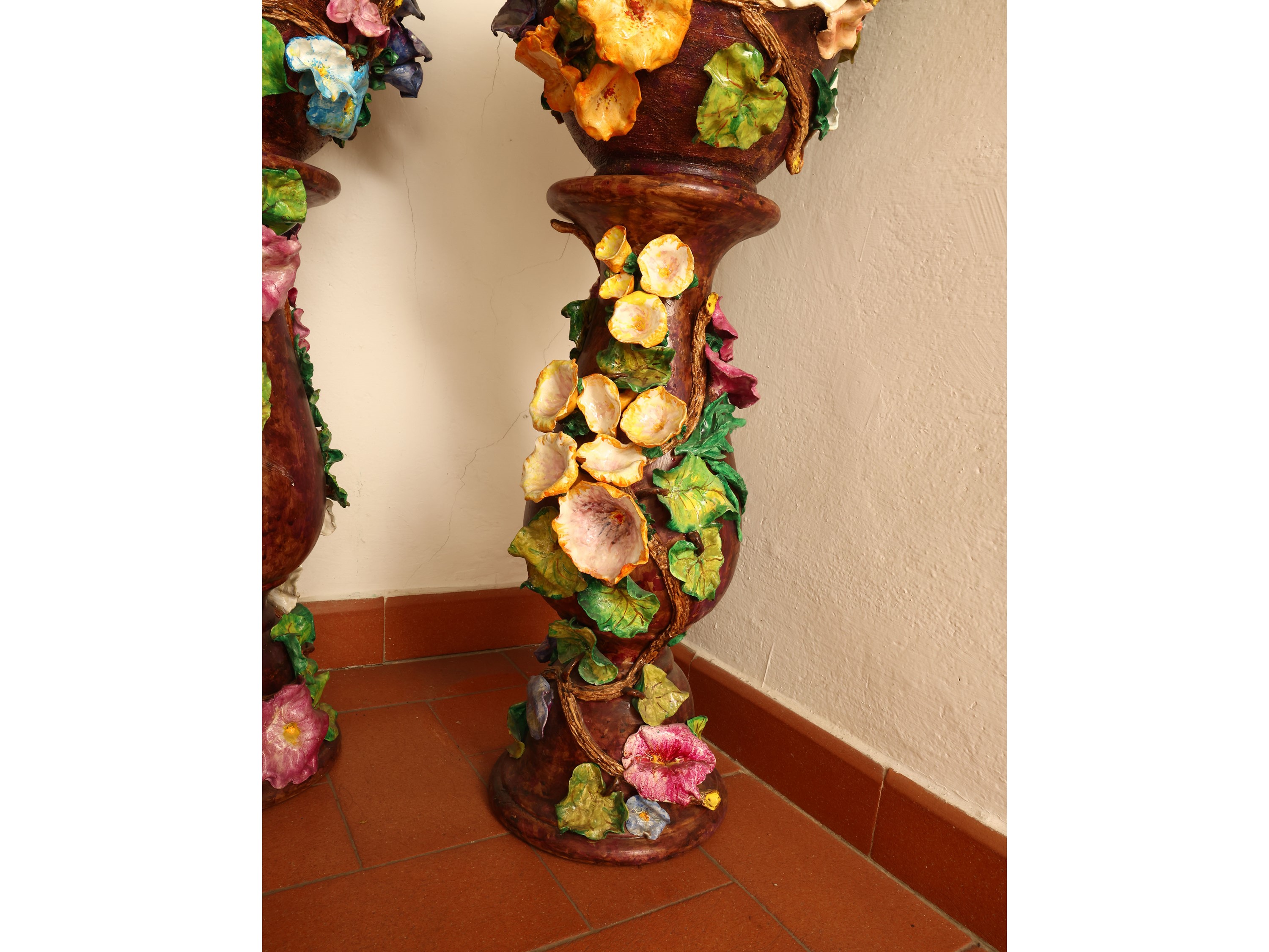 Coppia di colonne portavasi in ceramica policroma, decorate con motivi floreali in rilievo