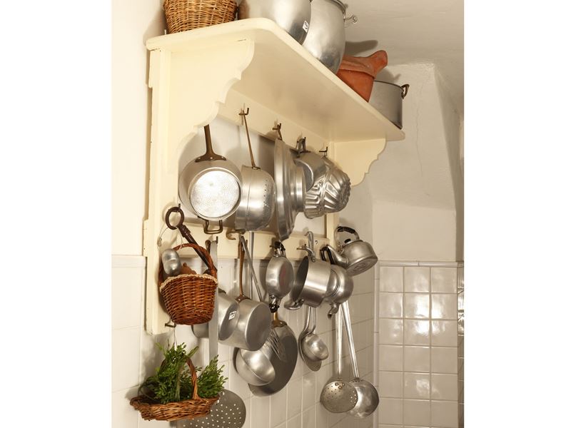 Piattaia rustica in legno tinto bianco con assortimento di tegami ed accessori in alluminio