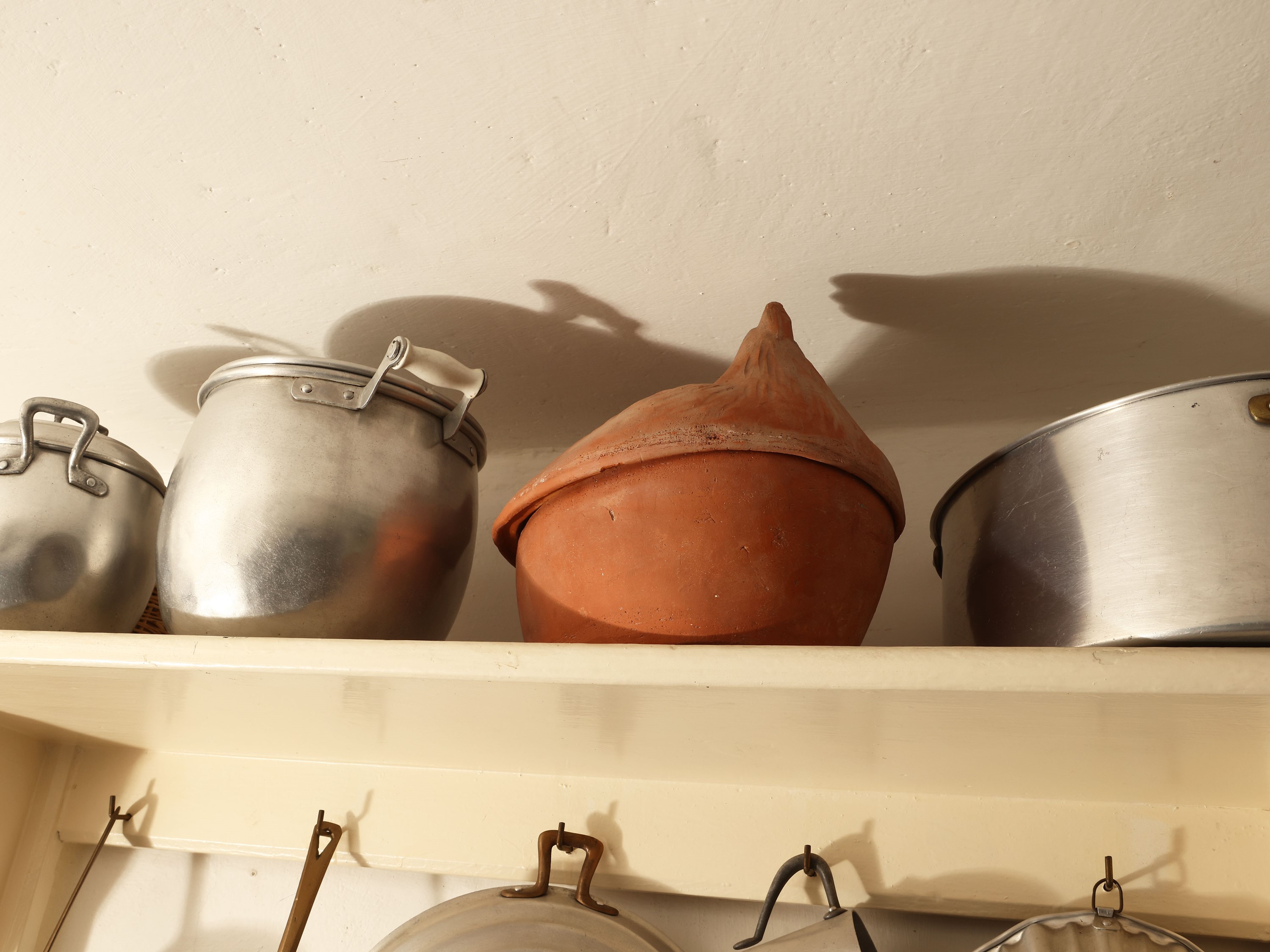Piattaia rustica in legno tinto bianco con assortimento di tegami ed accessori in alluminio