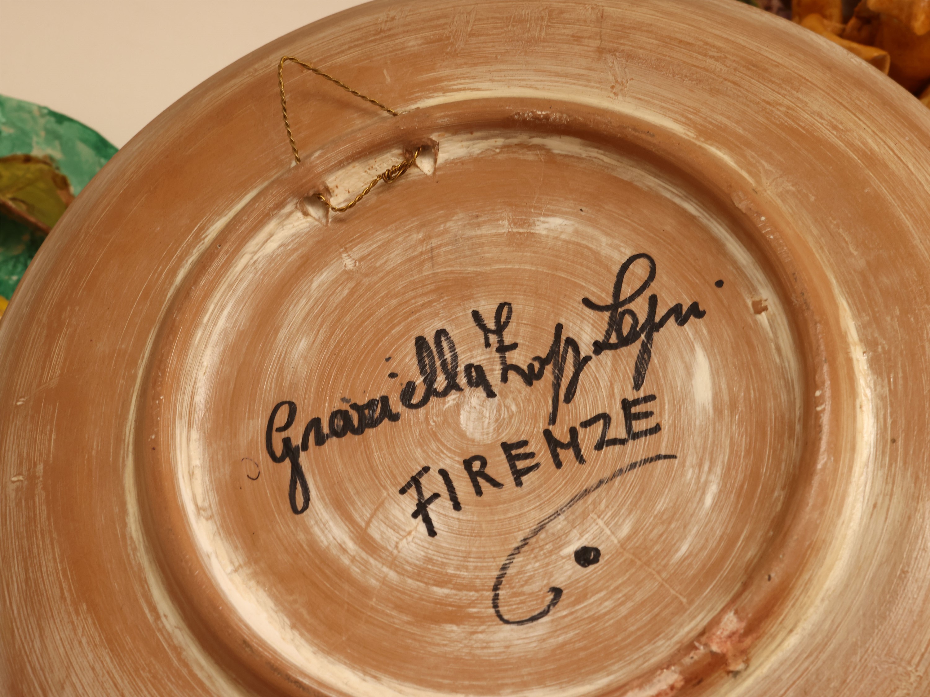 Quattro piatti da parata in ceramica policroma, decorati con motivi floreali in rilievo